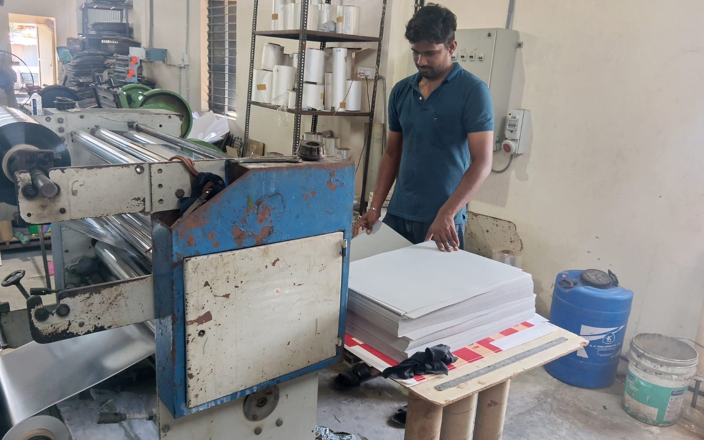 Film lamination machine running at the Perundurai plant, with laminated sheets stacked at delivery